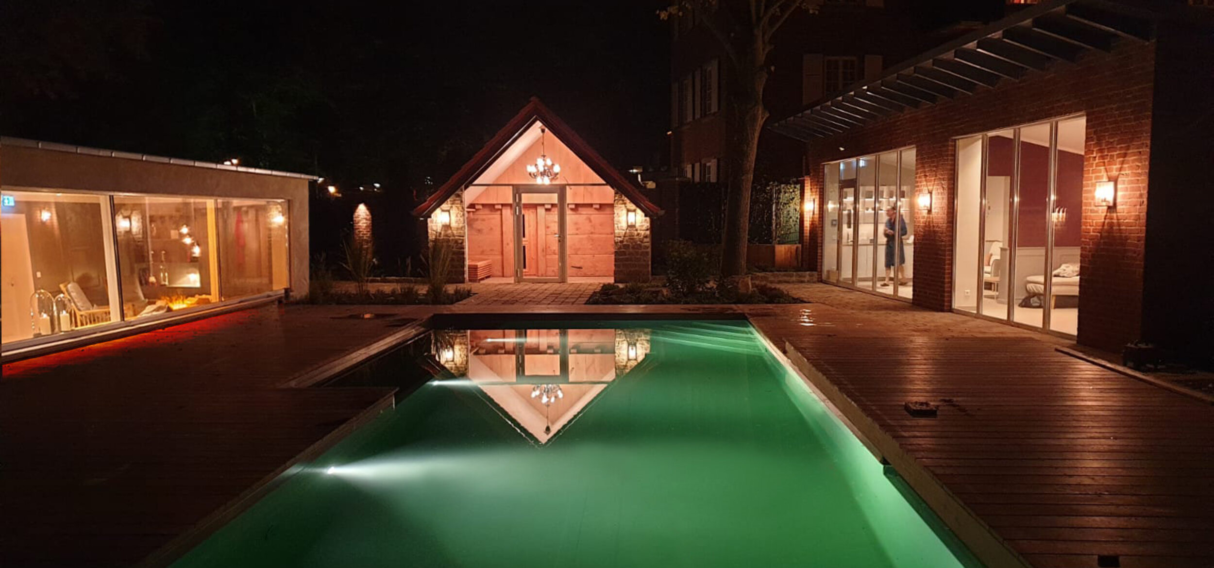 The natural pool at the Hotel-Residence “Klosterpforte” in Marienfeld with the lights switched on at night