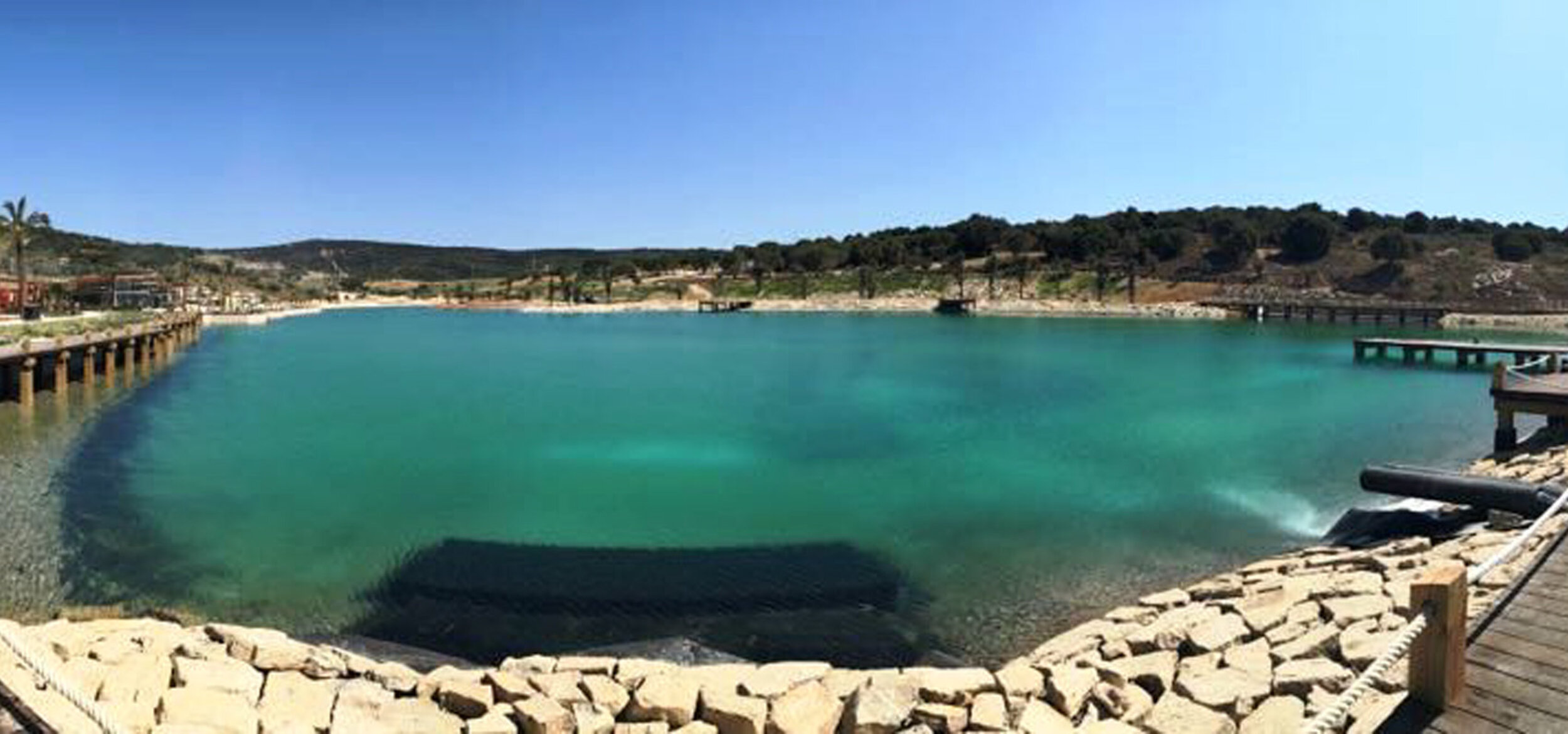 View over the water surface with Balena system of the “Spain Beach Club” in Sotogrande, with a hilly landscape in the background