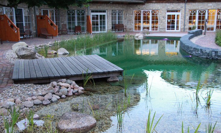 Swimming pond with Balena system with lounger and bank planting at the wellness hotel SPA & nature resort “Seeschlösschen” in Senftenberg